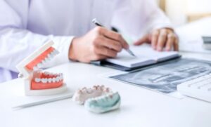 Dentist writing report working with tooth x ray and expecting dental billing review