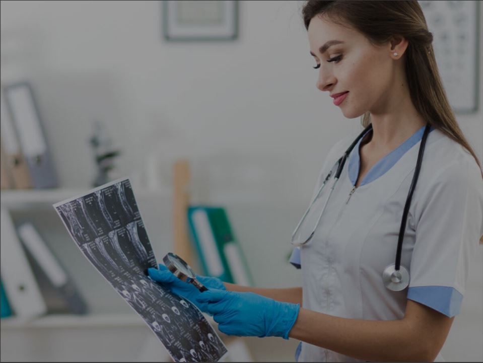 Orthopedic surgeon evaluating digital diagnostic imaging and managing clinical treatment documentation.